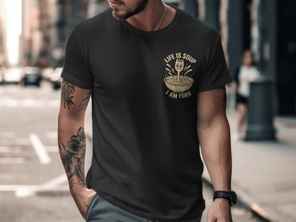Man wearing a black t-shirt with a graphic design on a city street.