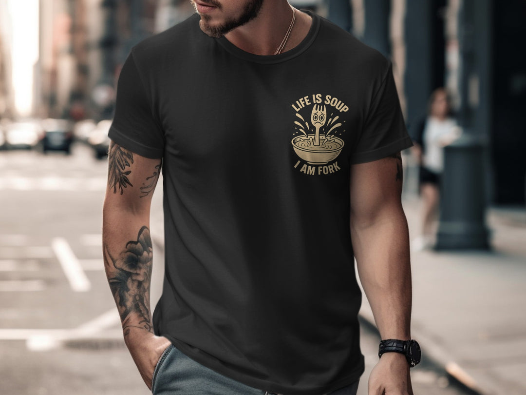 Man wearing a black t-shirt with a graphic design on a city street.