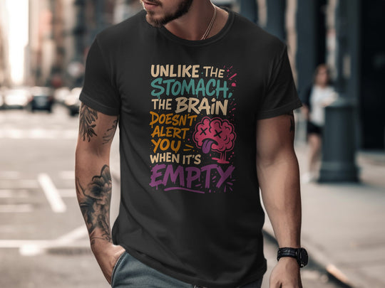 Man wearing a black t-shirt with colorful text and brain graphic on a city street.