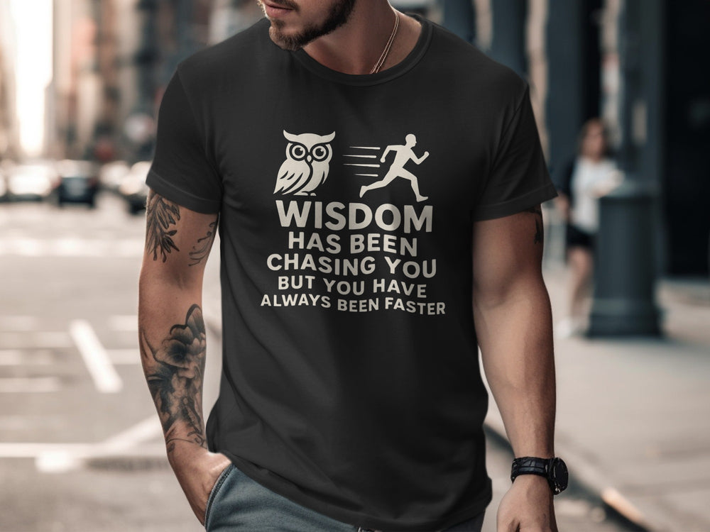 Man wearing a black t-shirt with a graphic and text on a city street.