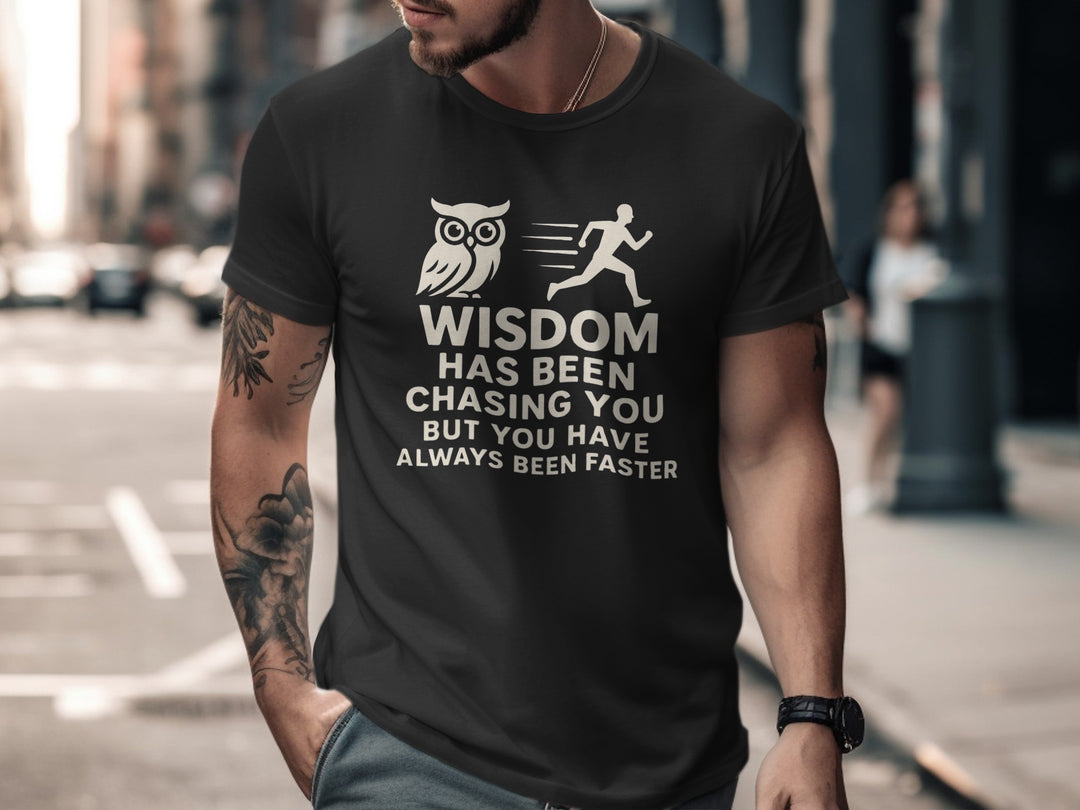 Man wearing a black t-shirt with a graphic and text on a city street.