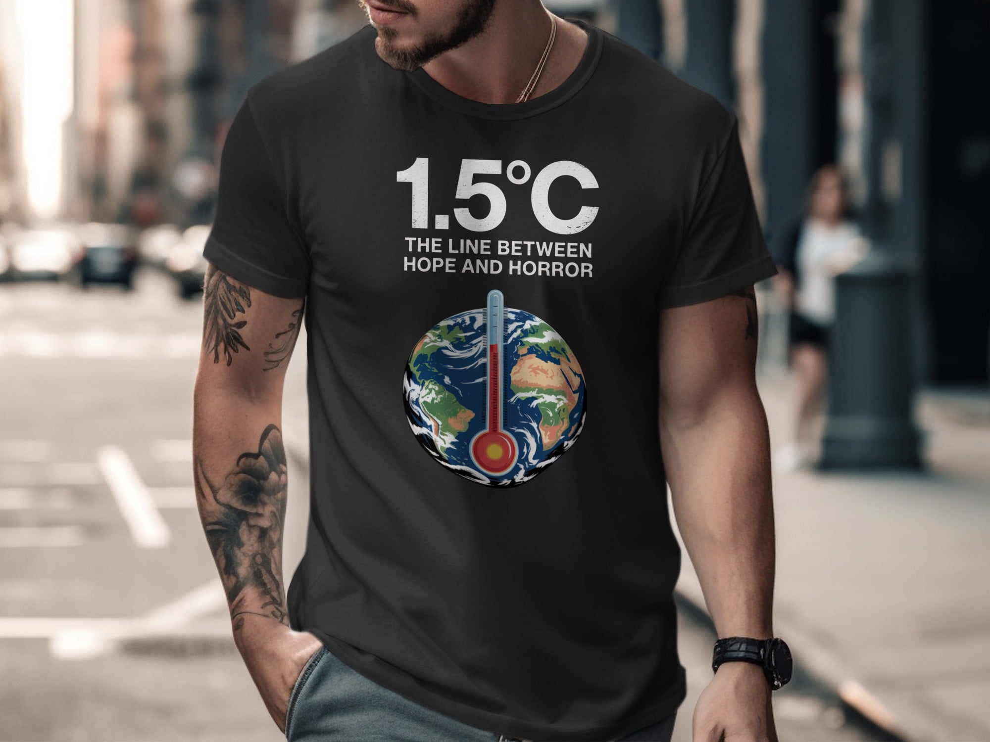 Person wearing a black t-shirt with a graphic and text about climate change in an urban setting.
