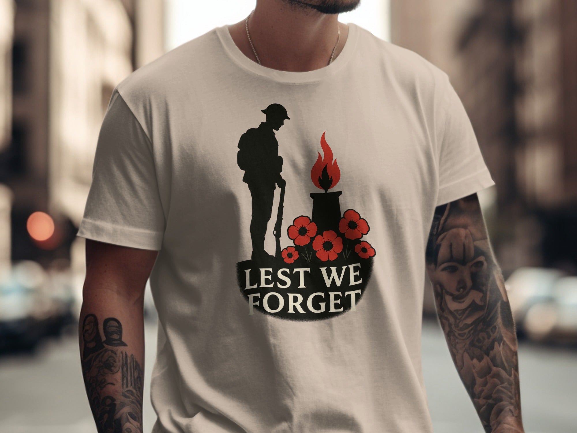 Person wearing a beige t-shirt with a memorial design and 'Lest We Forget' text.