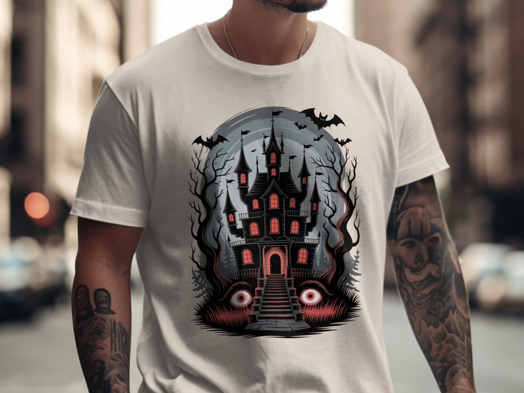 Person wearing a natural color t-shirt with a Halloween-themed design featuring a haunted house.
