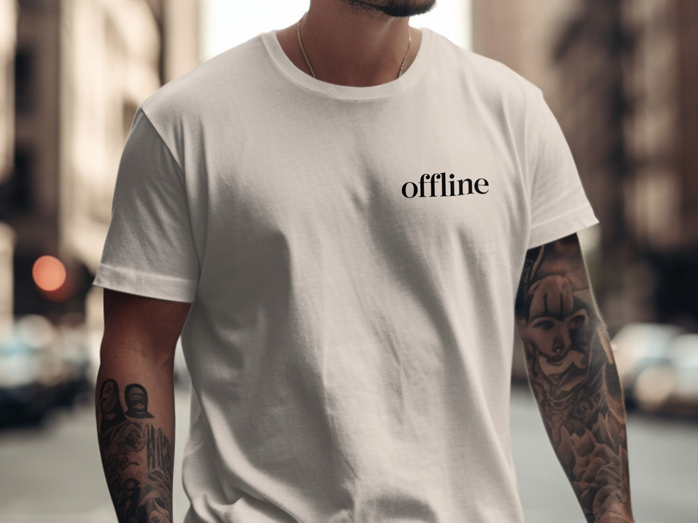 Person wearing a natural color t-shirt with 'offline' text on a city street.
