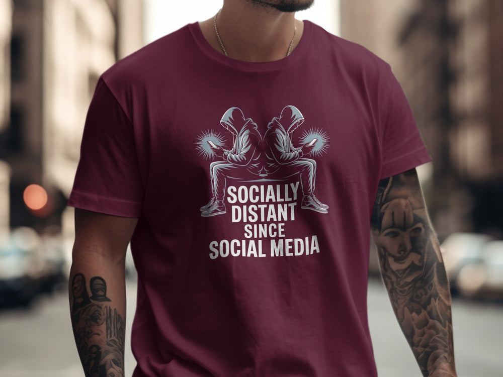 Person wearing a maroon t-shirt with a graphic and text in an urban setting