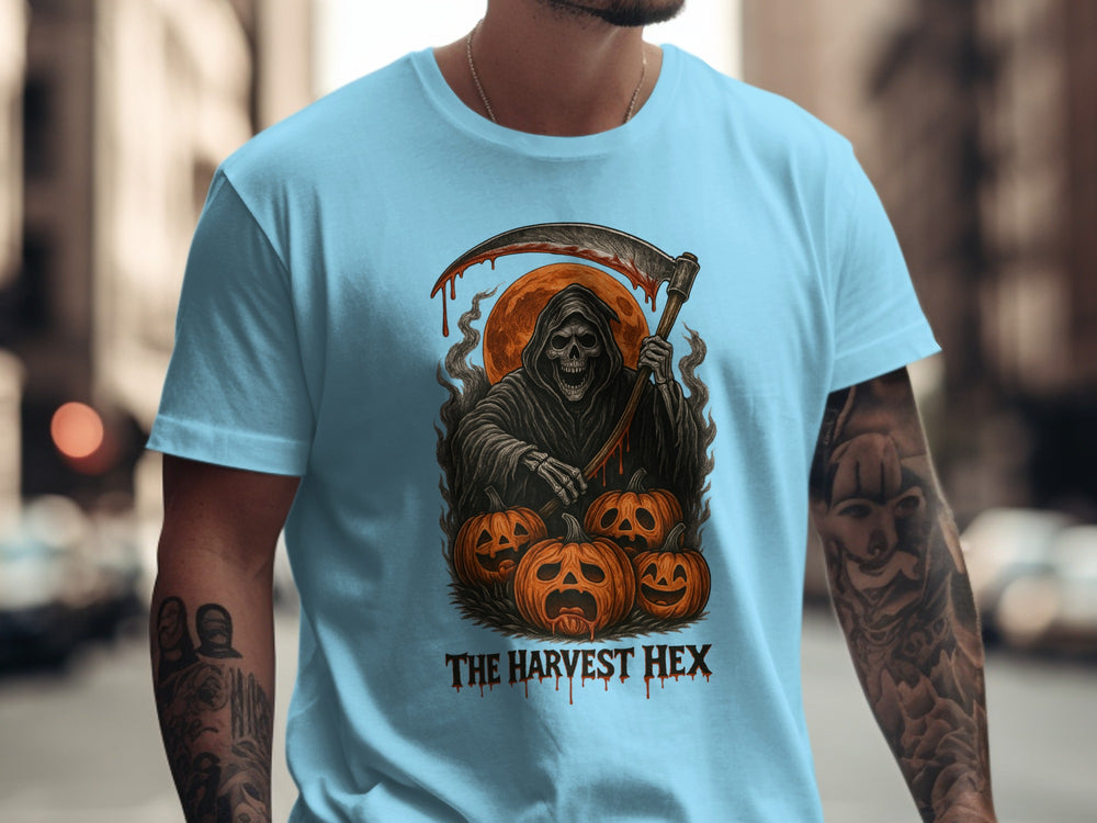 Person wearing a sky blue t-shirt with a graphic design of a Grim Reaper and pumpkins, with 'The Harvest Hex' text.