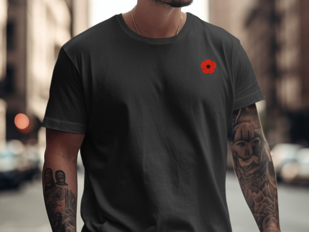 Person wearing a black t-shirt with a red logo on a city street