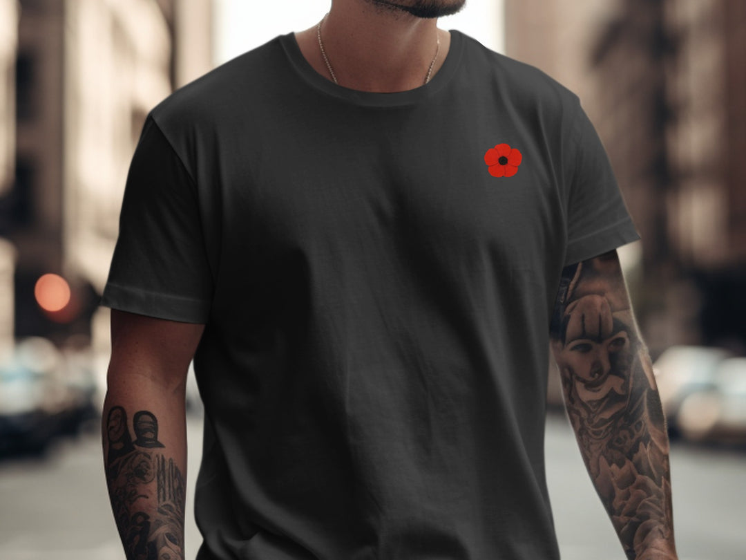 Person wearing a black t-shirt with a red logo on a city street