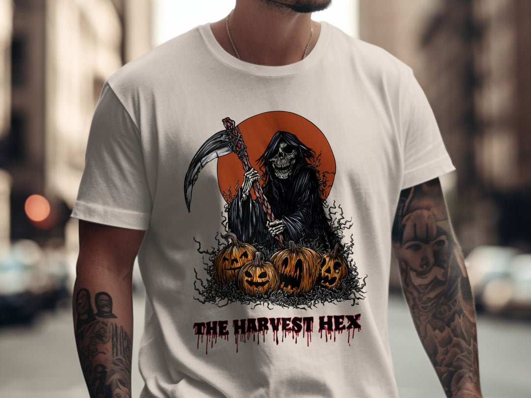 Person wearing a natural color t-shirt with a Halloween-themed design featuring a skeleton and pumpkins.