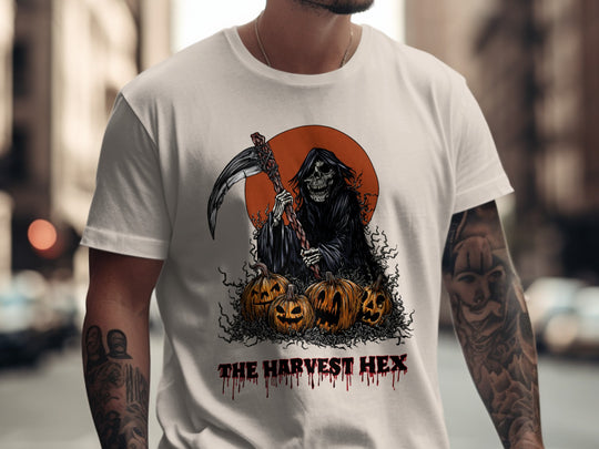 Person wearing a natural color t-shirt with a Halloween-themed design featuring a skeleton and pumpkins.