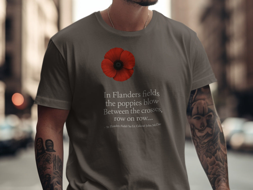 Person wearing a t-shirt with a red poppy and text on a city street.