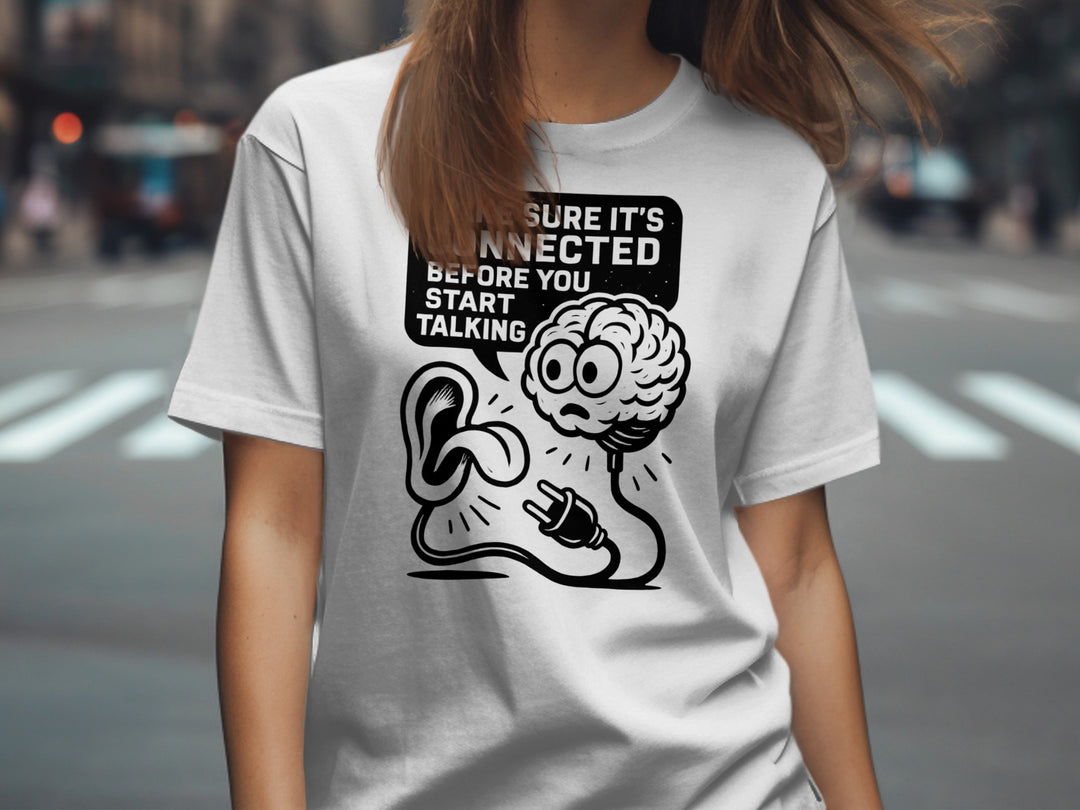 Person wearing a white t-shirt with a graphic design and text on a city street background