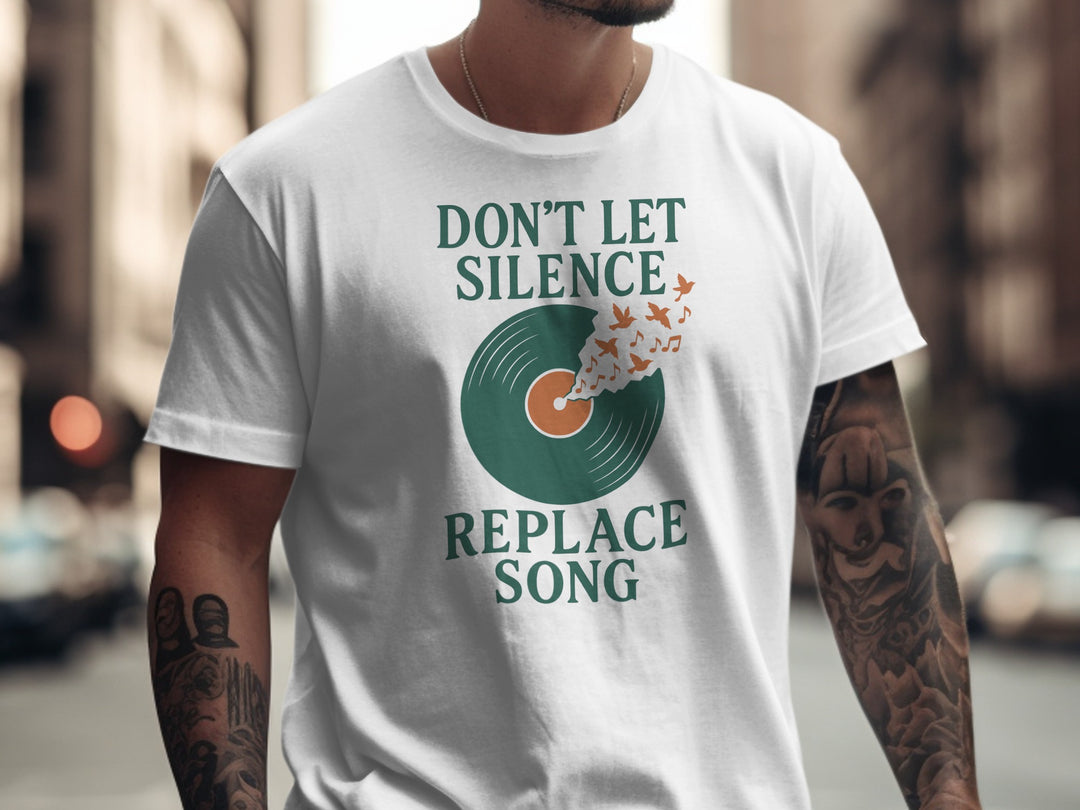 Person wearing a white t-shirt with a graphic and text 'Don't Let Silence Replace Song' on a blurred city street background.