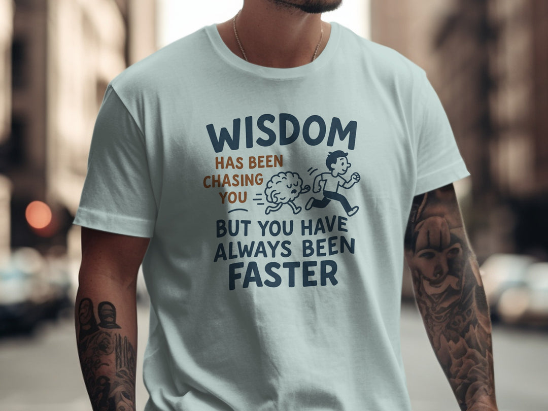 Person wearing a light blue t-shirt with a humour comment and graphic on a city street background.