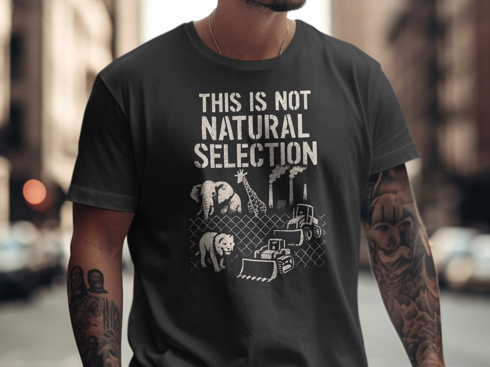Person wearing a black t-shirt with a graphic and text 'THIS IS NOT NATURAL SELECTION' in an urban setting.