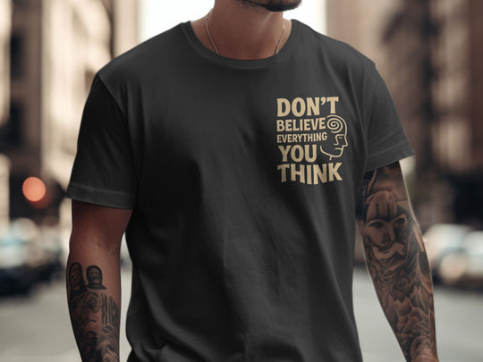 Person wearing a black t-shirt with 'DON'T BELIEVE EVERYTHING YOU THINK' text on a city street.