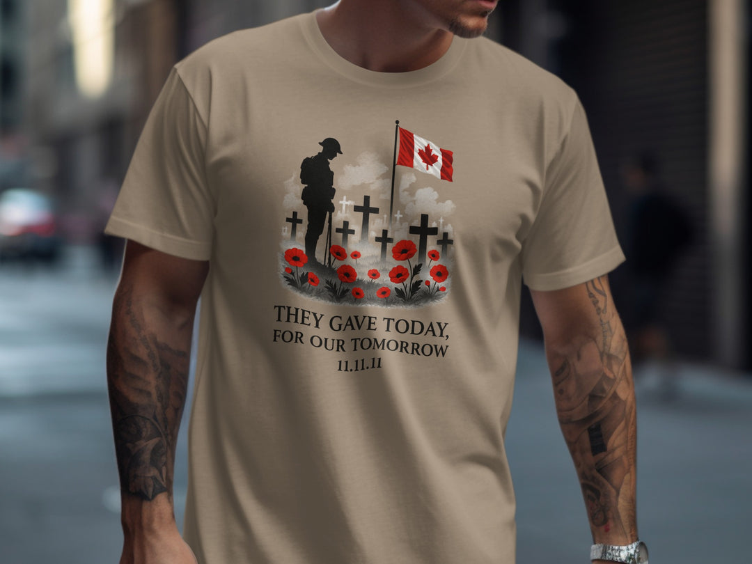 Person wearing a brown savana t-shirt with a graphic design featuring a soldier, crosses, and a Canadian flag.