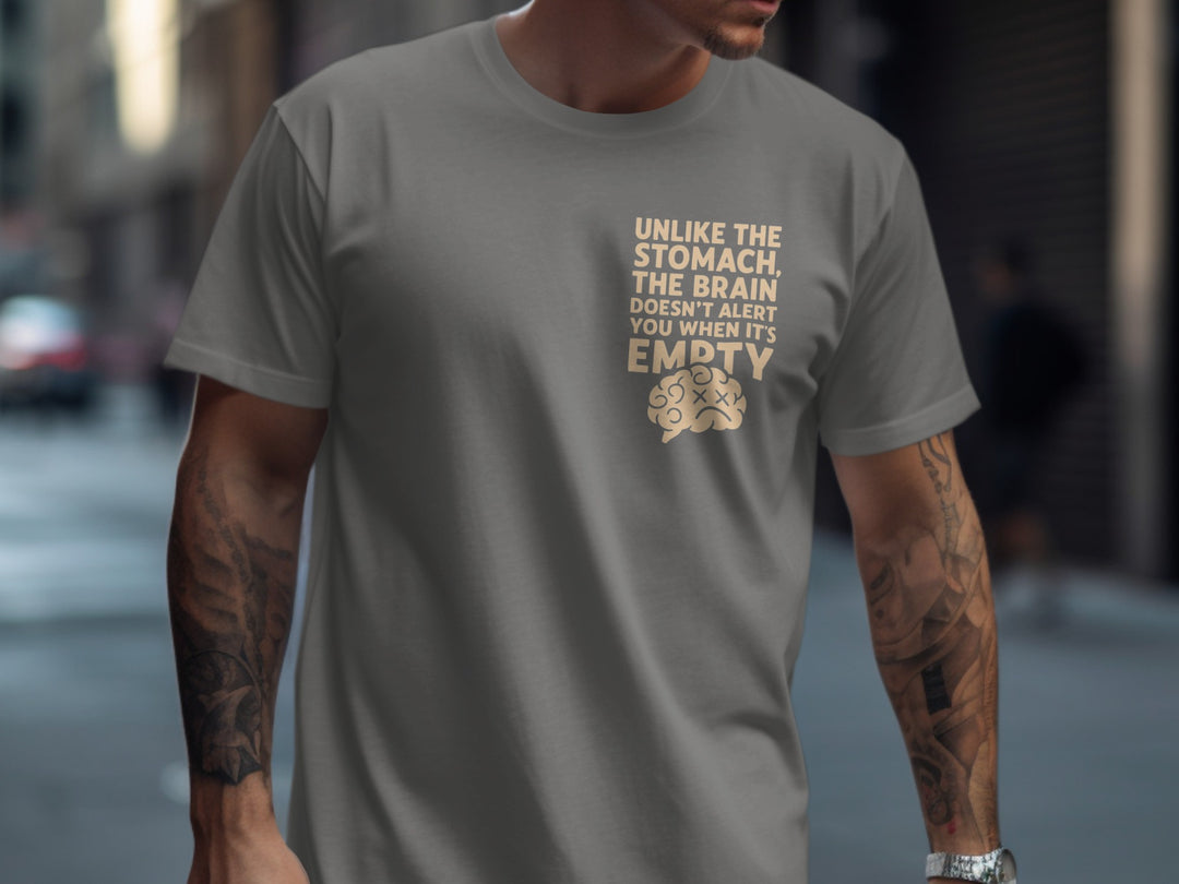 Person wearing a charcoal t-shirt with a humorous text design on a city street.