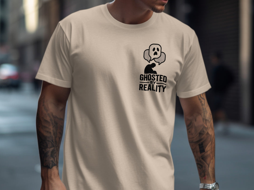 Person wearing a beige t-shirt with a graphic design and text on a blurred city street background