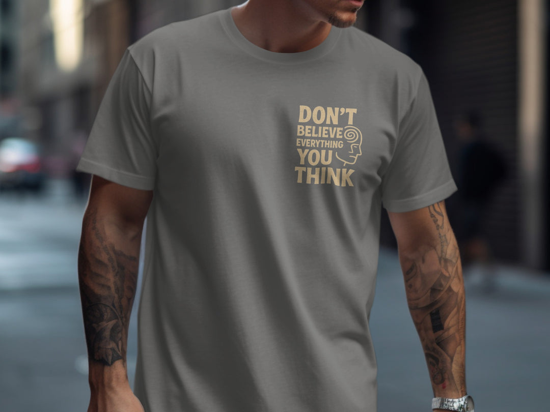 Person wearing a charcoal t-shirt with a motivational quote on a city street.