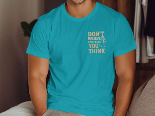 Person wearing a tropical blue t-shirt with a motivational quote indoors.
