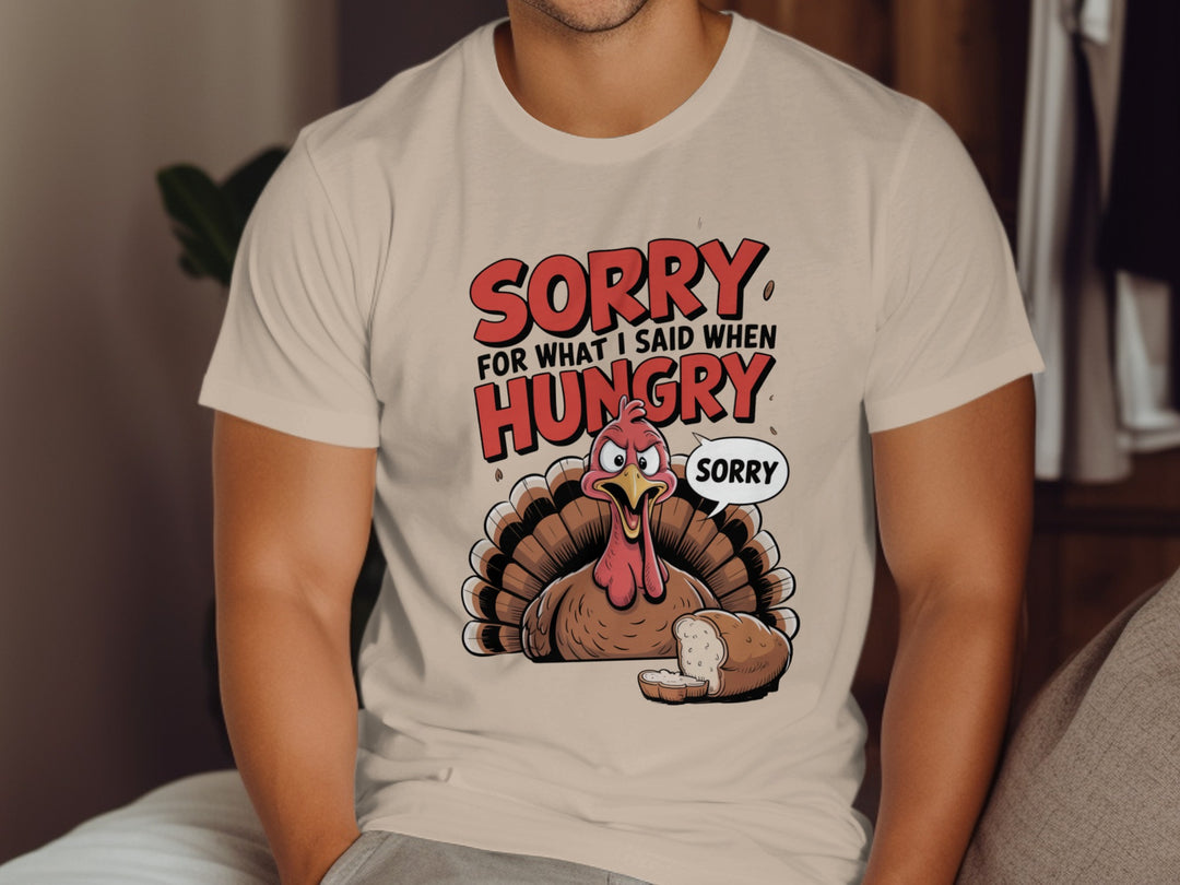 Person wearing a beige t-shirt with a turkey graphic and text 'Sorry for what I said when hungry'.