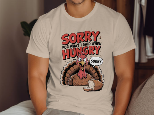 Person wearing a beige t-shirt with a turkey graphic and text 'Sorry for what I said when hungry'.