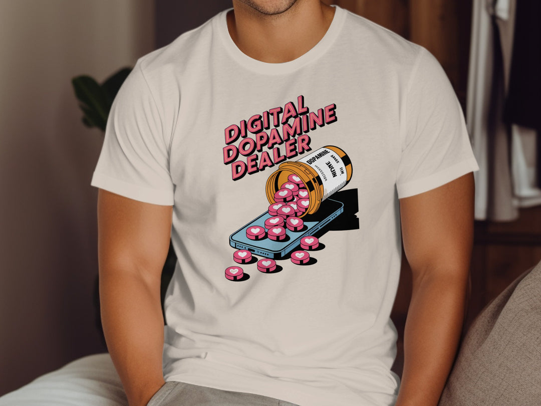 Person wearing a natural color t-shirt with a graphic design of a bottle labeled 'Digital Dopamine Dealer' and pink pills.