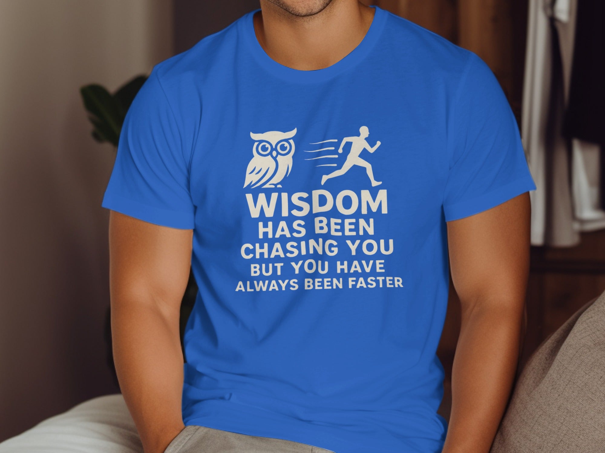 Person wearing a blue t-shirt with an owl and running man graphic and text.