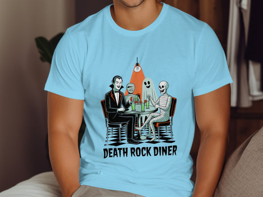 Person wearing a sky blue t-shirt with 'Death Rock Diner' graphic design.