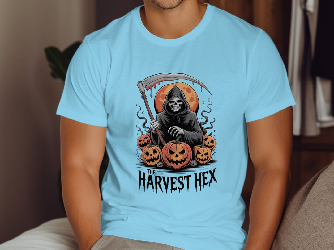 Person wearing a sky blue t-shirt with a Halloween-themed design featuring a skeleton and pumpkins.