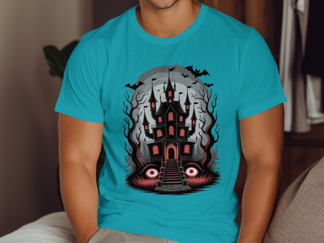 Person wearing a blue t-shirt with a haunted house graphic design.