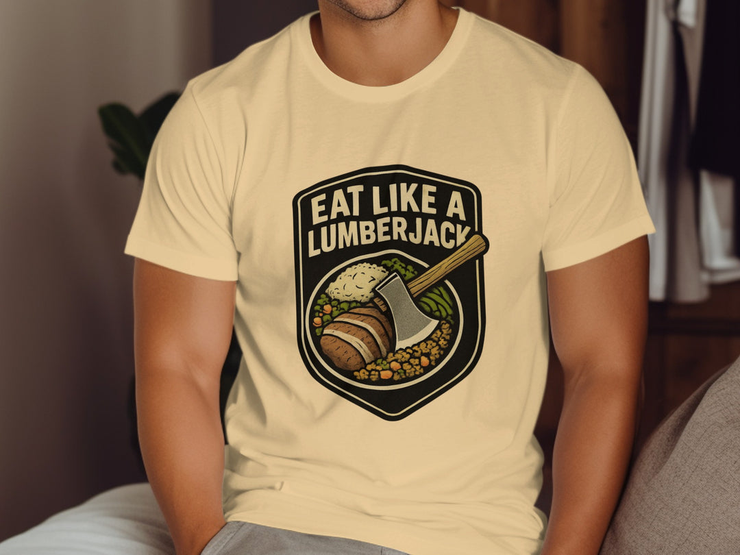 Person wearing a beige t-shirt with 'Eat Like a Lumberjack' graphic design.