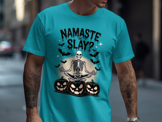 Person wearing a turquoise t-shirt with a Halloween-themed design featuring a skeleton and pumpkins.