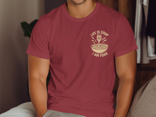 Person wearing a maroon t-shirt with a graphic design and text.