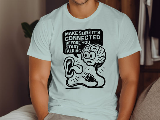 Person wearing a light blue t-shirt with a graphic design and text.