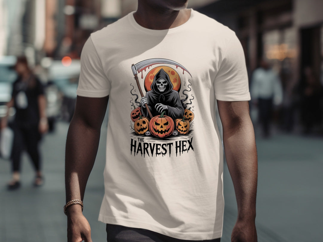 Person wearing a natural color t-shirt with 'Harvest Hex' design featuring a Grim Reaper and pumpkins on a city street.