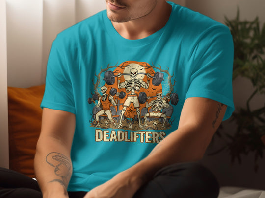 Person wearing a turquoise t-shirt with a graphic design of skeletons lifting weights and the word 'DEADLIFTERS'.