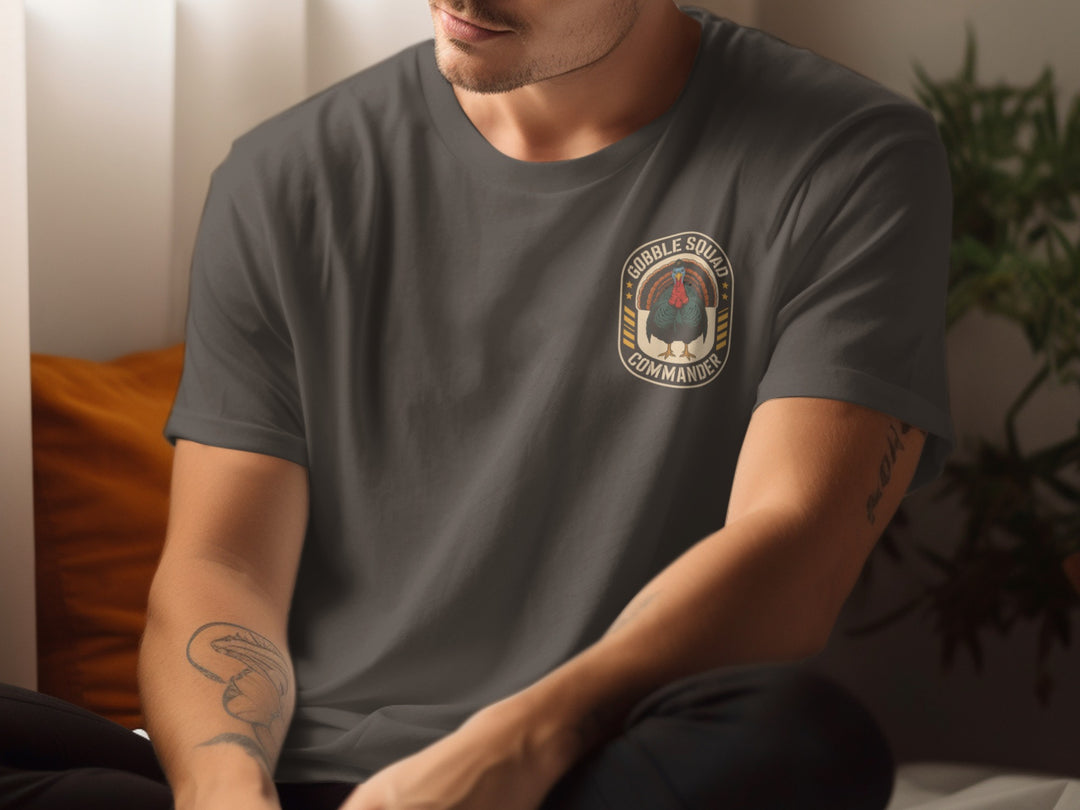 Person wearing a dark chocolate t-shirt with a logo sitting indoors.