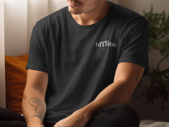 Person wearing a black t-shirt with 'offline' text in a casual setting.