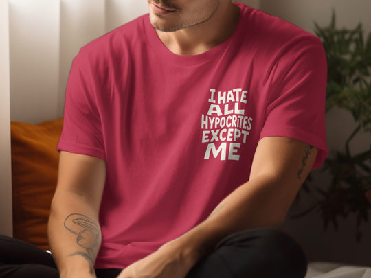 Person wearing a red t-shirt with text sitting indoors.
