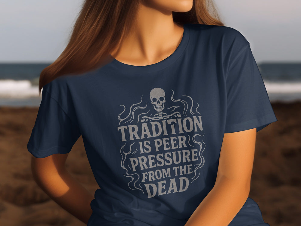 Person wearing a navy blue t-shirt with a skull design and text on a beach.