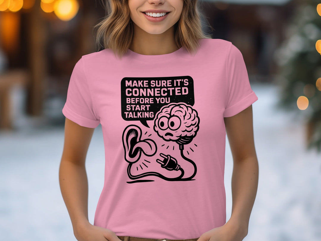 Person wearing a pink t-shirt with a graphic design and text.