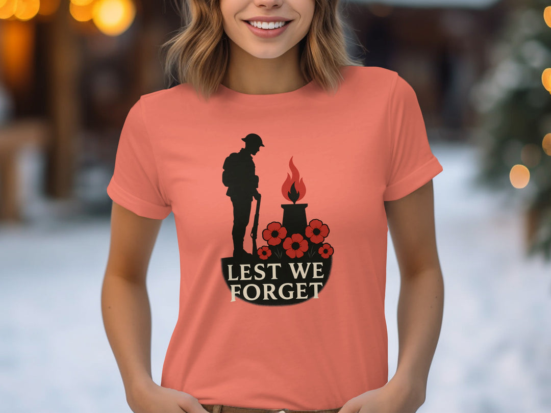 Person wearing a coral t-shirt with a memorial design and 'Lest We Forget' text.