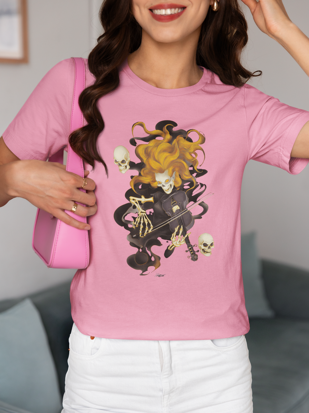 Person wearing a pink t-shirt with a graphic design, standing in an indoor setting.