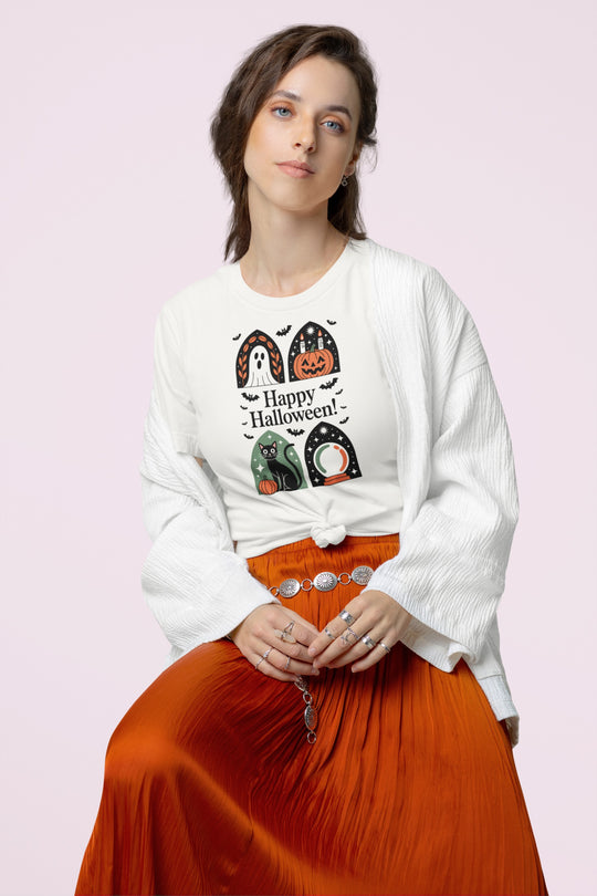 Woman wearing a white Halloween-themed shirt with graphics on a light pink background