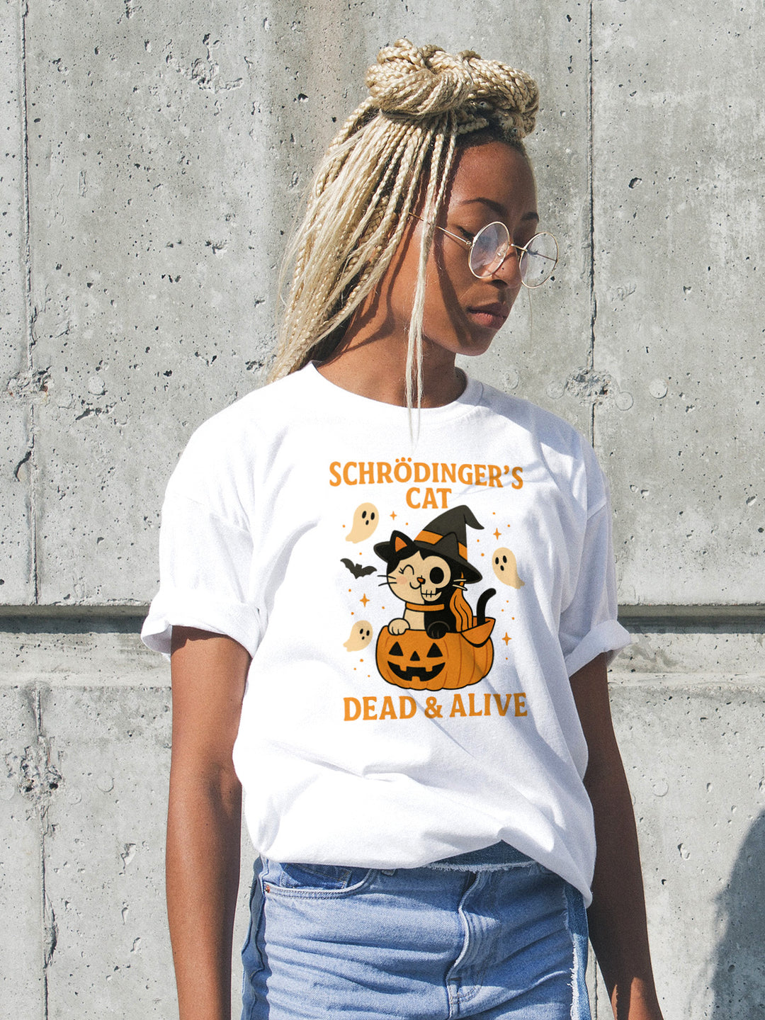 Person wearing a white t-shirt with a Schrödinger's cat graphic against a concrete wall.